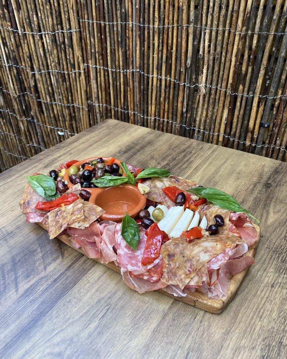 A sharing board of cured meats, cheese and olives